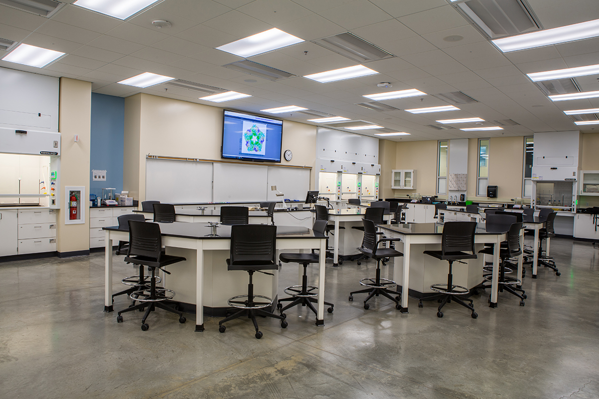 Woman using her computer in the kitchen counter drinking a glass of milk